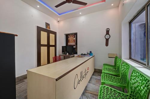 an office with a desk and two green chairs at Collection O CHITRA LODGE 