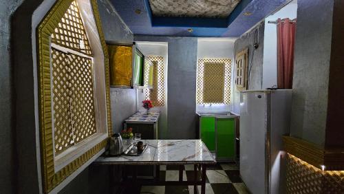 a small room with a table and a refrigerator at Shared Room near Pyramids! in Cairo