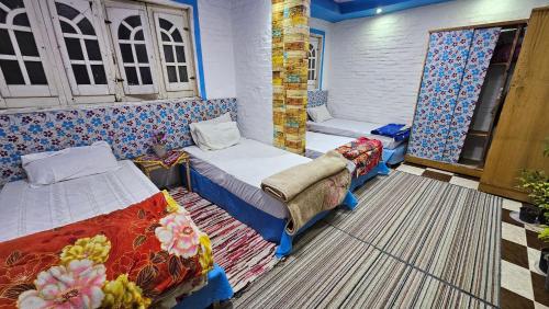 a room with two beds and a couch at Shared Room near Pyramids! in Cairo