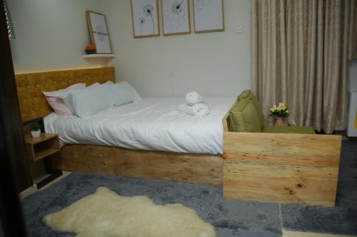 1 dormitorio con 1 cama con marco de madera en ENz Lovely Apartment 9, en Bungoma