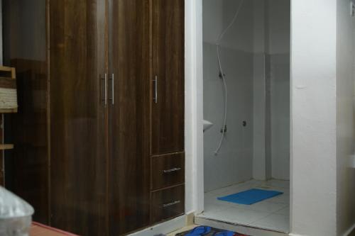 a bathroom with a shower and a wooden cabinet at ENz Lovely Apartment 9 in Bungoma