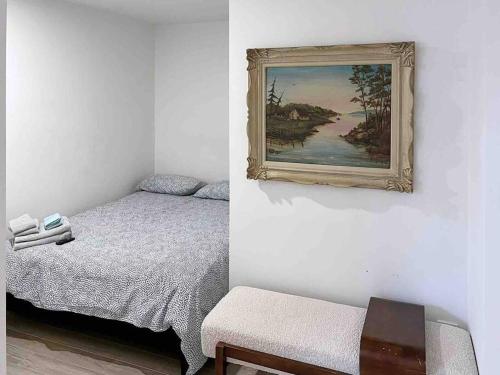 a bedroom with a bed and a painting on the wall at Chalet les jasmins Orford in Orford