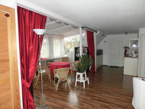 uma sala de estar com uma mesa e cortinas vermelhas em Auftanken im Grünen _ just4you_b.Berlin em Neuenhagen