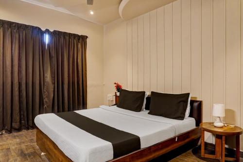 a bedroom with a large bed and a window at Collection O Hotel Nanashree Grand in Pune