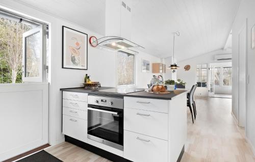 a kitchen with white cabinets and a stove top oven at Beautiful Home In Dronningmølle in Dronningmølle