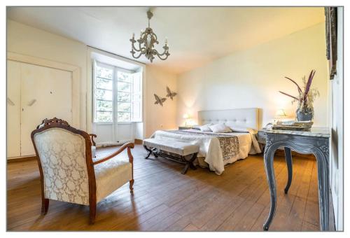 a bedroom with a bed and a table and a chair at Finca Villa Ángeles in San Rafael