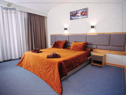 a hotel room with a bed with an orange bedspread at Karvan Sanatorium Naftalan in Naftalan