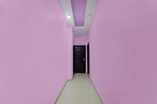 a corridor with a door in a white room at OYO Flagship The Imperial Inn in Patna