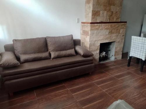 a brown couch in a living room with a fireplace at Güemes Apart in San Juan