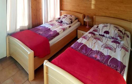 - une chambre avec 2 lits et une couverture rouge dans l'établissement Pet Friendly Home In Maszewo With Wifi, à Maszewo