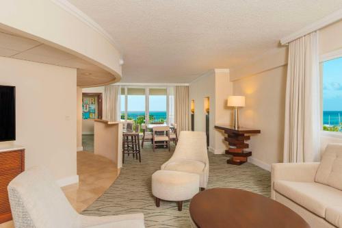 Hilton Aruba Caribbean Resort & Casino في شاطئ بالم إيغل: غرفة معيشة مطلة على المحيط