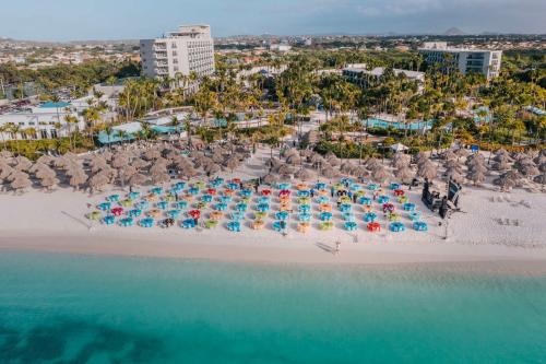 an aerial view of a beach with chairs and umbrellas at Hilton Aruba Caribbean Resort & Casino in Palm-Eagle Beach