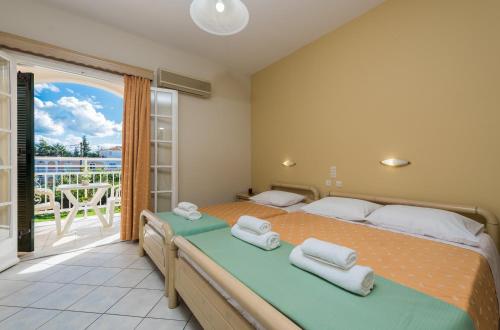 a bedroom with a large bed and a balcony at Olga Studios - 1 in Tsilivi