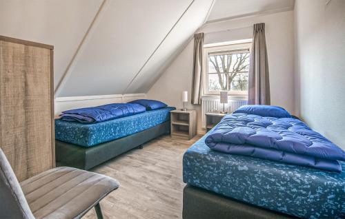 1 dormitorio con 2 camas, silla y ventana en Beautiful Home In Den Ham With Kitchen, en Den Ham