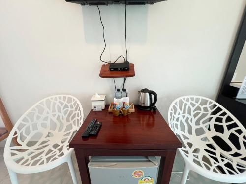 On Green Resort في Ban Huai Sua: طاولة صغيرة عليها كرسيين وصانع قهوة