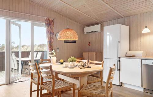 a kitchen and dining room with a table and a refrigerator at Amazing Home In Rømø With Wifi in Bolilmark