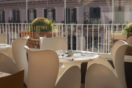 a white table and chairs in a room with a window at Airone Hotel in Naples