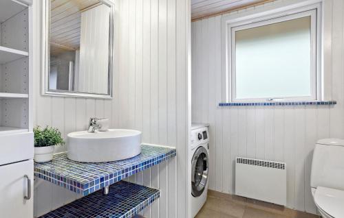 a bathroom with a sink and a washing machine at Amazing Home In Rm With Wifi in Bolilmark