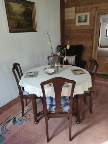 a dining room table with two chairs and a white table cloth at Alfapartmány in Krásná Lípa