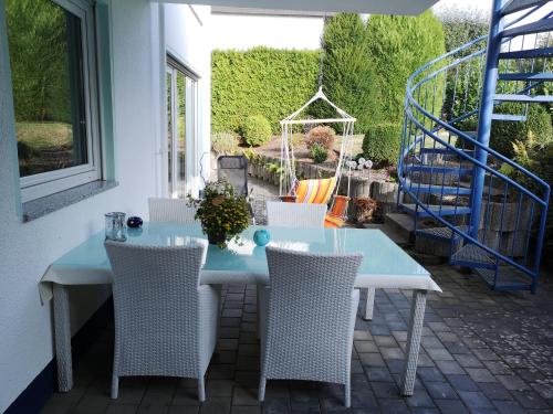 een blauwe tafel en stoelen op een patio bij Ferienwohnung am Park - Vulkanferien in Plaidt