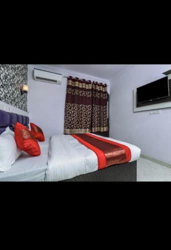 a bedroom with a bed with red pillows at HOTEL AKASH CONTINENTAL in New Delhi