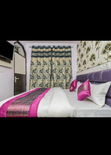 a bedroom with a bed with purple and white sheets and pillows at HOTEL AKASH CONTINENTAL in New Delhi