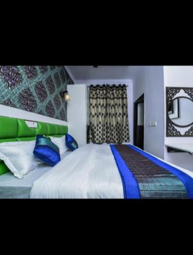 a bedroom with a large bed with blue pillows at HOTEL AKASH CONTINENTAL in New Delhi