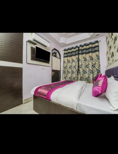 a bedroom with a pink bag sitting on a bed at HOTEL AKASH CONTINENTAL in New Delhi