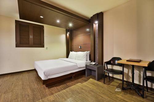 um quarto de hotel com uma cama e uma secretária em HOTEL airport June em Incheon