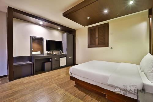 Un dormitorio con una cama grande y un televisor. en incheon Airport Hotel June, en Incheon