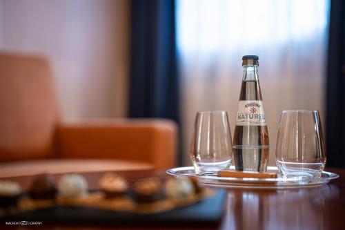 a bottle of beer sitting on a table with two glasses at Schlosshotel Westerholt in Herten