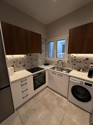 a kitchen with a sink and a washing machine at Central Stylish Lux Apartments in Lamía