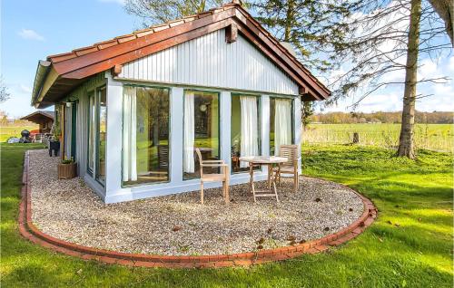 a small cottage with a table and chairs in the grass at Pet Friendly Home In Sehlen With Wifi in Sehlen