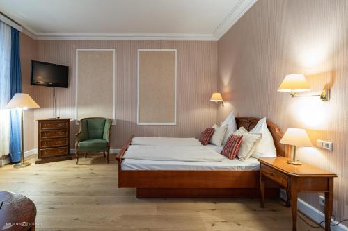 a hotel room with a bed and a chair at Schlosshotel Westerholt in Herten
