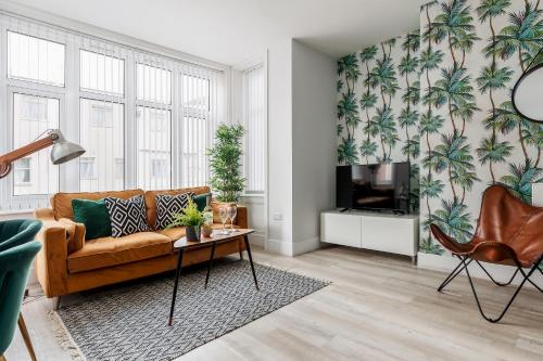 a living room with a couch and a tv at Sea Breeze Apartments in Bournemouth