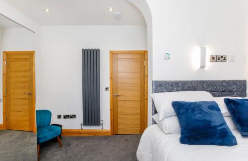 a bedroom with a bed and a blue chair at The Residence At The Lawrence Apartments in York