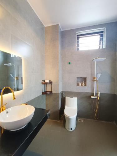 a bathroom with a sink and a toilet at Khe Sanh Luxury Hotel in Hương Hóa