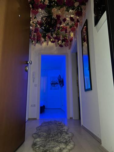 a hallway with a blue room with flowers on the ceiling at Tea Modern Apartament in Pristina