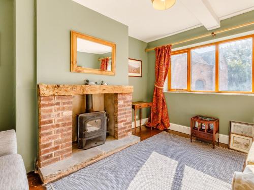 a living room with a brick fireplace and a mirror at 8 Bed in Abbots Bromley 79321 in Abbots Bromley