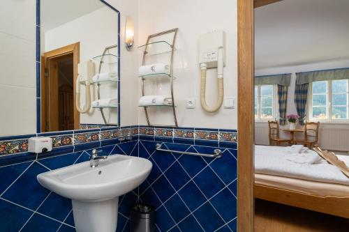 a bathroom with a sink and a mirror at Pension Slunečnice & Restaurace Farma in Špindlerův Mlýn