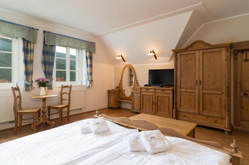 a bedroom with a bed and a tv and a table at Pension Slunečnice & Panorama Restaurace Farma in Špindlerův Mlýn