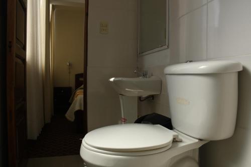 a bathroom with a white toilet and a sink at Hotel Express in La Paz