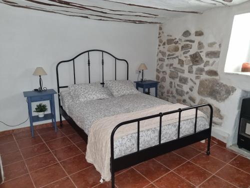 a bedroom with a bed and a stone wall at Casa el Mirador de Moratalla in Moratalla