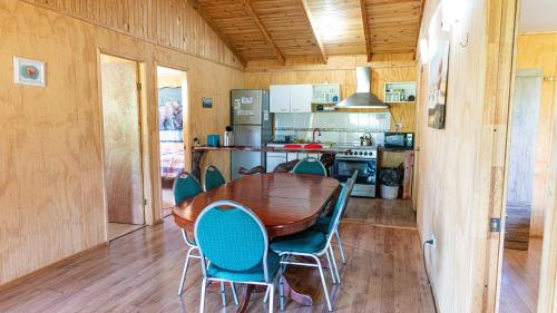 a dining room with a wooden table and chairs at Cabañas Estrella del Sur in Puerto Varas