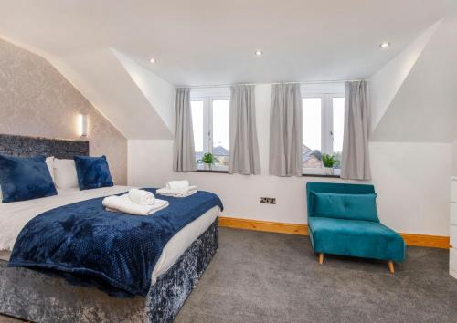 ein Schlafzimmer mit einem Bett und einem blauen Stuhl in der Unterkunft The Hideaway At The Lawrence Apartments in York
