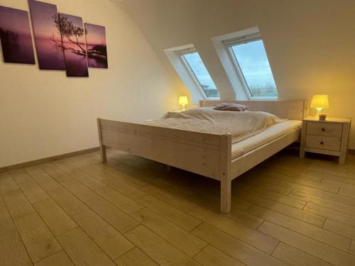 a bedroom with a bed with two lamps and two windows at Immensee App F in Ehst