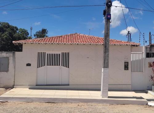 a white house with a red roof and a pole at Casa Macao Tibau do Sul in Tibau do Sul