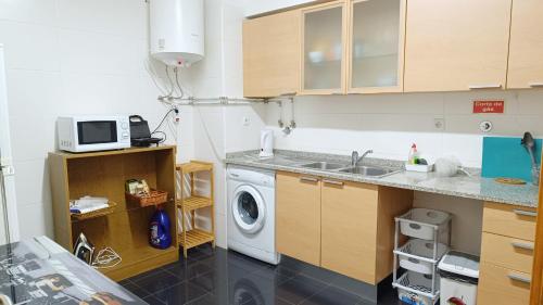 a kitchen with a washing machine and a sink at Refúgio Garajau Madeira in Caniço