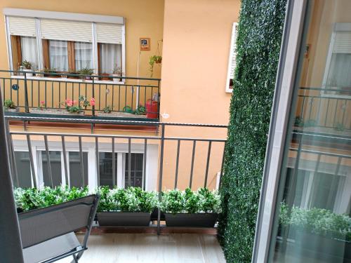 uma varanda com plantas e um banco em frente a um edifício em Alojamiento Beethoven Luxury em Málaga
