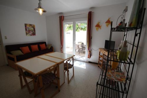 un salon avec une table et un canapé dans l'établissement 80m de la plage Appartement au rdc d'une maison 1 chambre 4 couchages cour LXRV9B, à Portiragnes